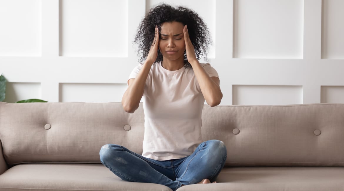 Upset stressed young african woman massage temples feel strong headache