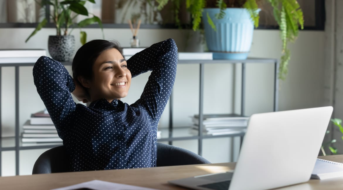 Indian employee resting leaned on office chair looking in distance