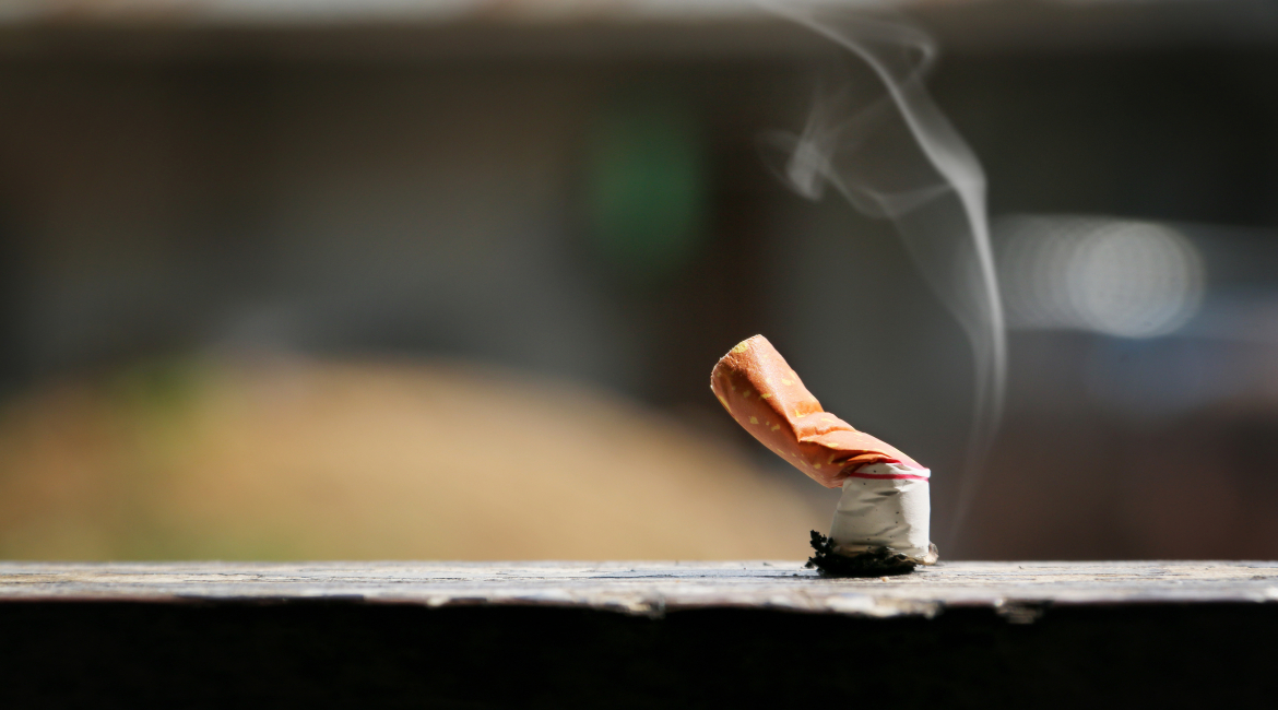 Brown color filter bottom cigarette on wooden floor.